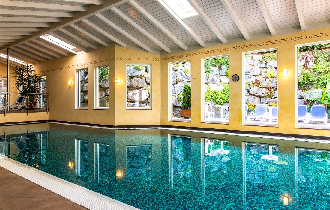 Schwimmbad mit blauem Mosaik gefliest und Blick auf den Außenbereich