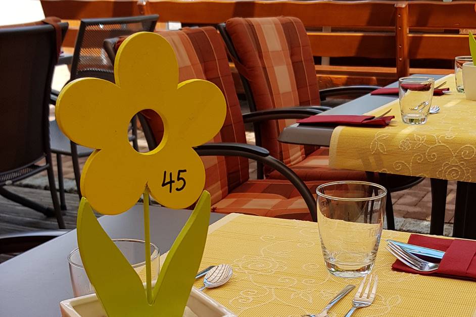 Sommerdeko mit Holzblumen auf der die Tischnummer geschrieben steht